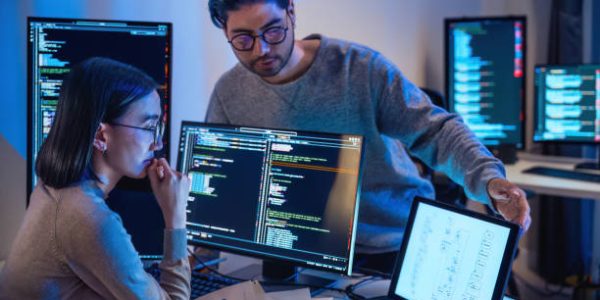 asian and Indian Developer  devops team discussion  about coding promgram with software computer at night in office